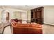 Spacious living room featuring a brown leather sofa and a custom built-in entertainment center at 119 E Palomino Dr, Tempe, AZ 85284