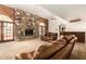 Living room with a large stone fireplace, wooden accent wall, and a bar area in the background at 119 E Palomino Dr, Tempe, AZ 85284