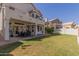 Large backyard with a covered patio, outdoor dining set, and expansive lawn, ideal for entertaining and recreation at 1343 E Amberwood Dr, Phoenix, AZ 85048