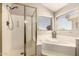 Bright bathroom features a glass-enclosed shower, a tub, and a sunlit window at 1343 E Amberwood Dr, Phoenix, AZ 85048