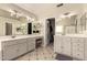 Bathroom features dual vanities, a dressing table, and an entrance to a walk-in closet at 1343 E Amberwood Dr, Phoenix, AZ 85048