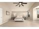Spacious bedroom features a ceiling fan, bedside tables with lamps, and light wood flooring at 1343 E Amberwood Dr, Phoenix, AZ 85048