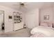 Bright bedroom featuring a ceiling fan, closet, and built-in shelving unit, creating a cozy and organized space at 1343 E Amberwood Dr, Phoenix, AZ 85048