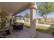 Relaxing covered patio with dining table, green lawn, and lush landscaping creating an inviting outdoor space at 1343 E Amberwood Dr, Phoenix, AZ 85048