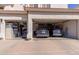 Spacious three car garage with two electric vehicles parked inside and shelving for storage at 1343 E Amberwood Dr, Phoenix, AZ 85048