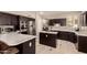 Well-lit kitchen with stainless steel appliances, dark wood cabinets and tile flooring at 1343 E Amberwood Dr, Phoenix, AZ 85048