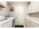 Functional laundry room with a modern washer and dryer, white cabinets, and a convenient folding countertop at 1343 E Amberwood Dr, Phoenix, AZ 85048