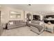 Spacious living room with modern gray sofas, neutral decor, and tile flooring at 1343 E Amberwood Dr, Phoenix, AZ 85048