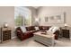 Inviting living room featuring tile floors, a comfortable leather sofa, and natural light at 1343 E Amberwood Dr, Phoenix, AZ 85048