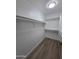 Walk-in closet with hardwood floors and multiple shelves for optimal storage and organization at 13606 N 130Th Ave, El Mirage, AZ 85335