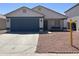 Charming single-story home featuring a blue garage door and low-maintenance desert landscaping at 13606 N 130Th Ave, El Mirage, AZ 85335