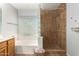 Bright bathroom featuring a glass block window, large bathtub, and a walk-in shower with decorative tile at 1381 W Gary Dr, Chandler, AZ 85224