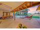 Relaxing covered patio with dining table and lounge chairs overlooking the shimmering pool and well manicured backyard at 14221 N 43Rd St, Phoenix, AZ 85032