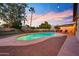 Beautiful backyard pool illuminated by string lights and the vibrant sunset, perfect for evening relaxation and entertaining at 14221 N 43Rd St, Phoenix, AZ 85032