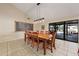 Spacious dining area with a large wooden table, modern lighting, and sliding glass doors to the patio at 14221 N 43Rd St, Phoenix, AZ 85032