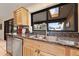Close-up of the kitchen sink area with wooden cabinetry, granite countertops and stainless steel dishwasher at 14221 N 43Rd St, Phoenix, AZ 85032