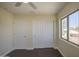 Bright bedroom features a ceiling fan, and a window with a view of the home's landscaping at 14719 N 176Th Ave, Surprise, AZ 85388