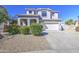Beautiful two-story home with a three-car garage, arched entryway, and green, flowering shrubs at 14719 N 176Th Ave, Surprise, AZ 85388