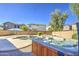 Backyard showcasing a hot tub and pool area, surrounded by desert landscaping and a privacy fence at 14719 N 176Th Ave, Surprise, AZ 85388
