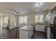 Bright kitchen features an island with barstool seating, stainless steel appliances, and a ceiling fan at 14719 N 176Th Ave, Surprise, AZ 85388