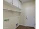 An uncluttered laundry room features overhead storage and a utility sink hookup, ready for modern appliances at 14719 N 176Th Ave, Surprise, AZ 85388
