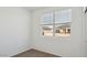 Bedroom with a neutral color carpet, white walls, window with view of the house next door at 1534 E Mason Dr, Casa Grande, AZ 85122