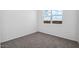 Bright bedroom featuring new gray carpeting, fresh white walls, and a window offering natural light at 1540 E Mason Dr, Casa Grande, AZ 85122