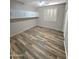 This bedroom features wood-look tile flooring, white cabinets, and natural light from a window with white shutters at 15656 W Desert Mirage Dr, Surprise, AZ 85379