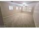 Bright, carpeted bedroom featuring multiple windows and a ceiling fan at 15656 W Desert Mirage Dr, Surprise, AZ 85379