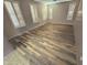 Empty bedroom showcasing stylish wood-look flooring and shuttered windows for a bright, modern living space at 15656 W Desert Mirage Dr, Surprise, AZ 85379