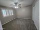 A bedroom features a ceiling fan, a large window, and sliding-door closet at 15656 W Desert Mirage Dr, Surprise, AZ 85379