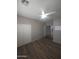 This bedroom features wood-look tile flooring, a ceiling fan, and closet with bi-fold doors at 15656 W Desert Mirage Dr, Surprise, AZ 85379