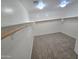 Empty walk-in closet with carpeting and wooden racks for hanging clothing at 15656 W Desert Mirage Dr, Surprise, AZ 85379