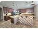 Spacious kitchen boasts granite countertops, dark wood cabinets, and a large center island with stone accents at 15656 W Desert Mirage Dr, Surprise, AZ 85379