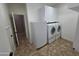 This laundry room features white cabinets, neutral walls, and a white washer and dryer at 15656 W Desert Mirage Dr, Surprise, AZ 85379