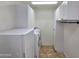 This laundry room features white cabinets, neutral walls, and a white washer and dryer at 15656 W Desert Mirage Dr, Surprise, AZ 85379