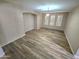 Spacious living room featuring wood-look tile flooring, recessed lighting and large windows with plantation shutters at 15656 W Desert Mirage Dr, Surprise, AZ 85379