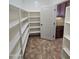 Walk-in pantry with ample shelving for organized storage, conveniently located near the kitchen at 15656 W Desert Mirage Dr, Surprise, AZ 85379