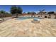 Resort-style backyard with a pool, fire pit, and travertine tile at 15656 W Desert Mirage Dr, Surprise, AZ 85379