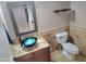 This powder room features a vessel sink with a granite countertop and a decorative mirror at 15656 W Desert Mirage Dr, Surprise, AZ 85379