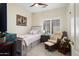 Comfortable bedroom with plantation shutters, a cozy chair and a light-colored walls at 15790 W Arrowhead Dr, Surprise, AZ 85374