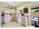 Bright kitchen features white appliances, modern countertops, and a window overlooking the backyard at 15790 W Arrowhead Dr, Surprise, AZ 85374