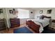 Comfortable bedroom featuring hardwood floors, a wooden dresser, and a decorative bed frame at 17200 W Bell Rd # 1622, Surprise, AZ 85374