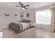 Inviting bedroom features a ceiling fan, neutral tones, sheer curtains, and decorative hanging plants at 1809 S Heritage --, Mesa, AZ 85210