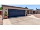 Attached garage with a dark blue door and concrete driveway, with desert landscaping at 1809 S Heritage --, Mesa, AZ 85210