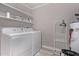 Convenient laundry room with a washer, dryer, and shelving for efficient organization at 1809 S Heritage --, Mesa, AZ 85210