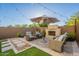 Charming backyard oasis featuring a brick fireplace, lush landscaping, and comfortable seating area at 1956 W Kinfield Trl, Phoenix, AZ 85085