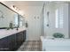Bathroom featuring double sinks, large glass enclosed shower, and patterned tile floors at 1956 W Kinfield Trl, Phoenix, AZ 85085