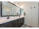 Bathroom featuring double sinks, a large mirror, stylish lighting, and patterned tile floors at 1956 W Kinfield Trl, Phoenix, AZ 85085