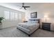 Cozy bedroom with a ceiling fan, neutral decor, shuttered windows, and comfortable bedding for a relaxing retreat at 1956 W Kinfield Trl, Phoenix, AZ 85085